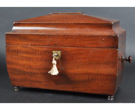 A 19th Century mahogany Regency tea caddy having a sarcophagus form lid with bombe sides and twin handles. The hinged lid ope