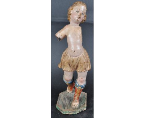 An 18th Century Century carved limewood figurine depicting a religious figure. The cherub putti figurine modelled striding wi