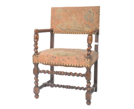 An 18th Century barley twist oak armchair having a tapestry upholstered back and seat rest with brass stud detailing. Barley 