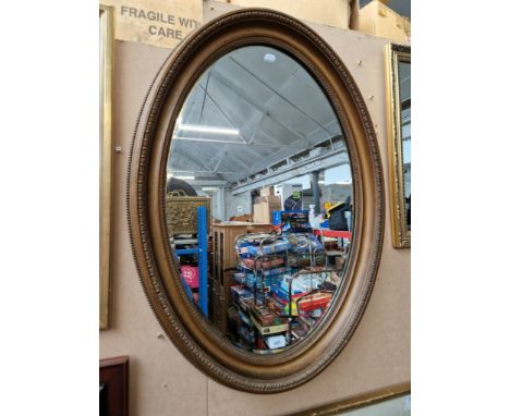 A vintage oval gilt framed mirror, 64cm x 89cm. 