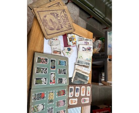 Various cigarette cards, and cigareete card albums together with a collection of vintage postcards. 