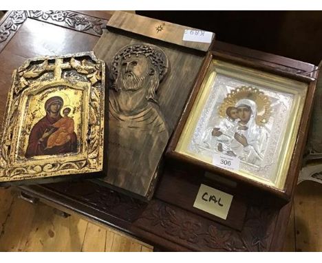 A group of three Russian  icons, a metal framed icon in silver and gold coloured metals, a gold leaf carved wooden panel and 