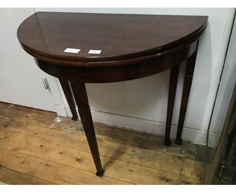 A George III style mahogany fold-over tea table, the hinged semi-elliptical top raised on square tapering legs (72 x 82 x 41c