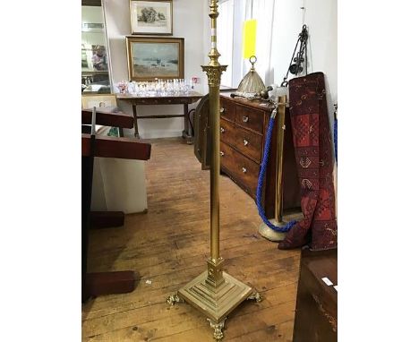 An Edwardian brass Corinthian column floor lamp, the fluted shaft raised on a stepped base and paw feet, formerly a paraffin 