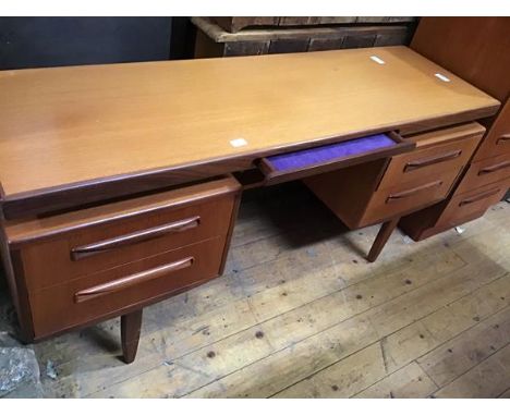 A G-Plan teak dressing table, with velvet-lined frieze drawer and four further drawers, raised on tapering legs, bears label,