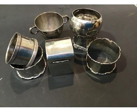 A mixed lot of hallmarked silver including napkin rings, a twin handled Christening mug and a miniature dome chased playing c