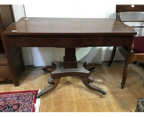 A Regency mahogany pedestal table, the rectangular top above a tapering column on hipped legs terminating in brass caps and c