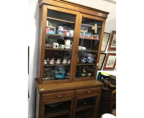 An Edwardian walnut cabinet bookcase, the top with a pair of glazed doors enclaong four adjustable shelve, the based with sim