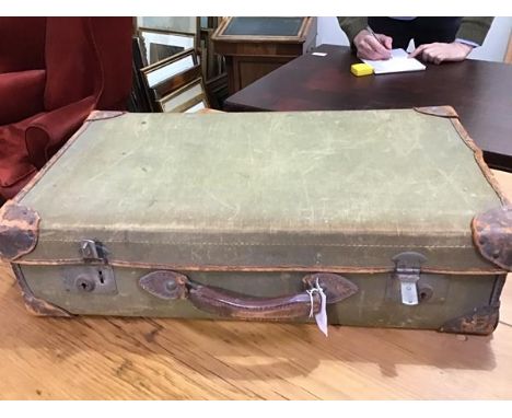 A vintage canvas covered suitcase containing various prints etc.