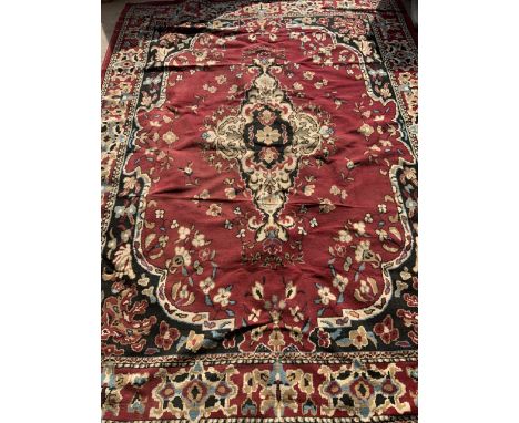 A large red, cream, black and blue modern carpet with large central medallion. W:325cm x H:236cm