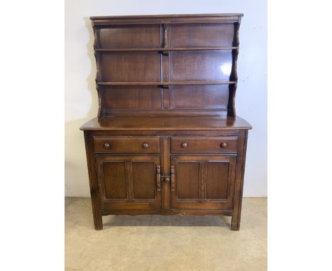 An Ercol style small dresser with two plate racks above sideboard base with two drawers and a cupboard.W:125cm x D:45cm x H:1