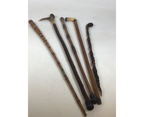 A collection of walking sticks to include a carved bamboo cane, a silver top and collar bone handled stick dated 1899. H:93cm