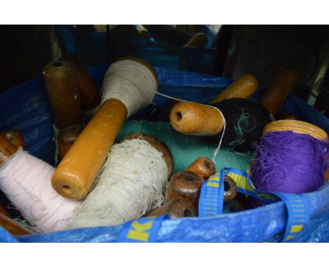 A quantity of large turned bobbin reels with cotton.