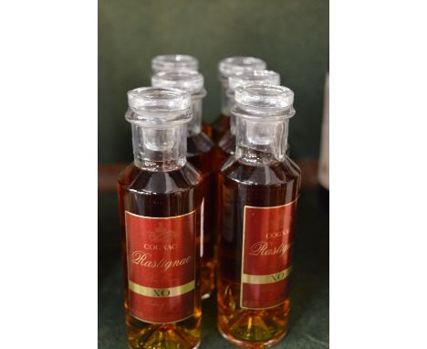 Six miniature bottles of Rastignac XO cognac.