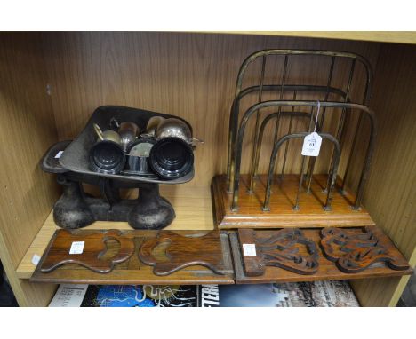 A brass and oak magazine rack, two book rests, kitchen scales and trophy cups.