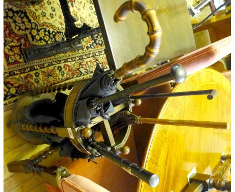 A 1920/30's oak four division stick stand with assorted umbrellas and parasols.