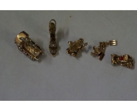 Five 9ct gold charms, comprising; a train, a shoe, a wizard, an old fashioned car and some gardening tools, (5) weight combin