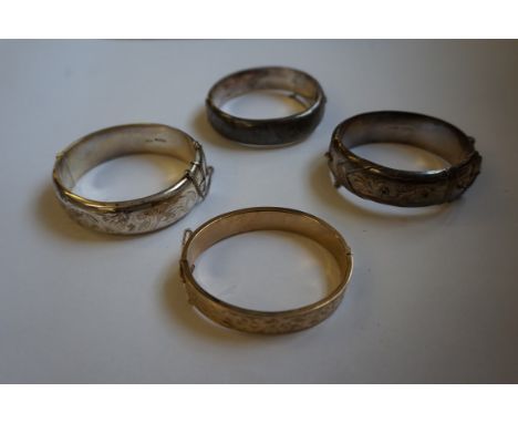 A 9ct gold hinged bangle, with engraved detail, weight 16g, together with, three silver hinged bangles, of various designs (4