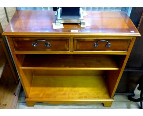 A reproduction yew wood bookcase, having two drawers above single adjustable shelf.