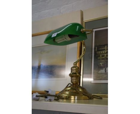 A modern brass mounted reading lamp with adjustable green glass shade.