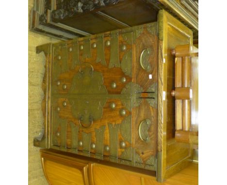 A stylish 19th Century Chinese elm cabinet, having two drawers and two panel cupboard, each having brass applied decoration, 