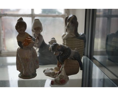 Four assorted Lladro figures to include a poodle and a basket of fruit, a girl holding a basket of oranges etc.