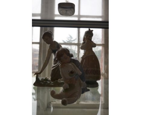 Three Lladro and Nao figures to include a child asleep on a Teddy bear.