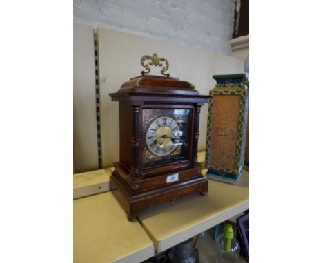 An early to mid 20th Century mantel clock having brass applied decoration.