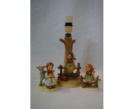 A Goebel Hummel table lamp and two figurines.