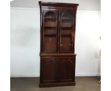 VICTORIAN MAHOGANY BOOKCASE ON CHEST LATE 19TH CENTURY with moulded stepped cornice above twin glazed doors enclosing four ad