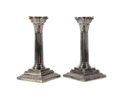 PAIR OF SILVER PLATED CORINTHIAN COLUMN CANDLESTICKS EARLY 20TH CENTURY with fluted columns to stepped basesProvenance: The H