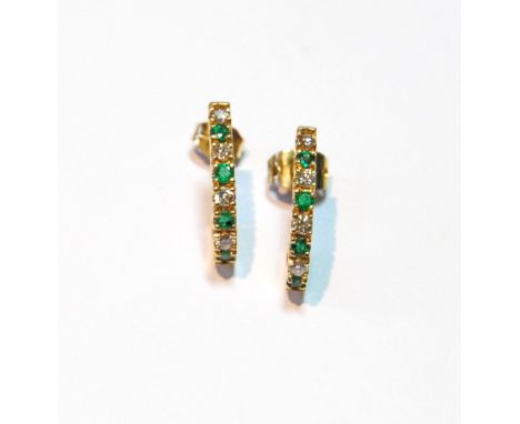 Pair of diamond and emerald earrings of comma shape.