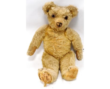 Early 20th century teddy bear, probably Chad Valley, with button in the right ear, hunched back, jointed arms and legs, growl