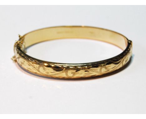9ct gold hinged bangle, half engraved, 10.9g.
