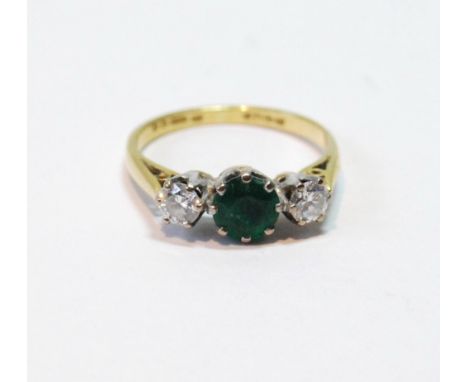 Three-stone ring with circular emerald and diamond brilliants in 18ct gold, 1977, size K½. Condition Report Some wear, emeral