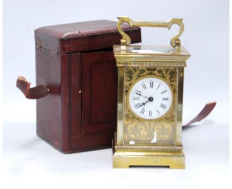 Brass carriage clock mounted by a shaped loop handle, floral chased fretwork face, white enamelled dial, Roman numerals, rais