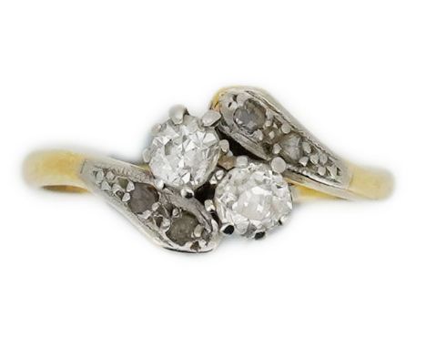 A diamond toi-et-moi ring, early 20th century, of crossover design, set with circular- and rose-cut diamonds, mounted in gold