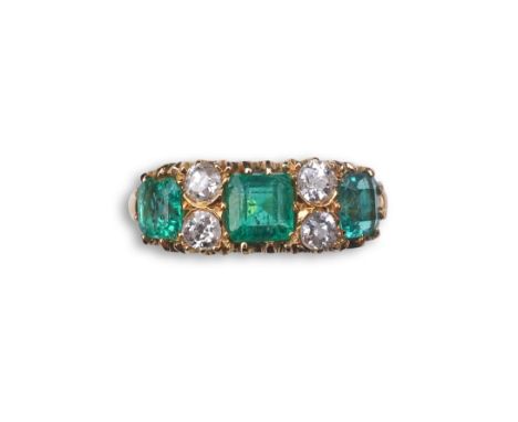 A late Victorian emerald and diamond ring, circa 1901, set with three step-cut emeralds totalling approximately 1.50 carats, 