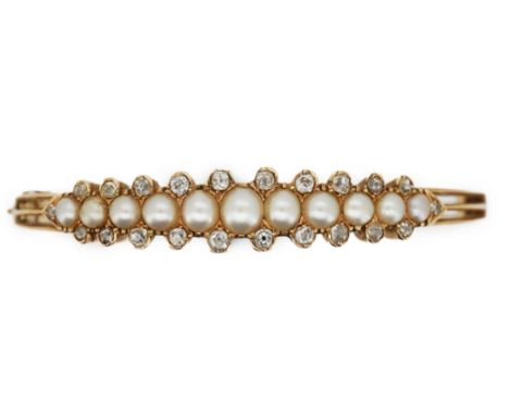An Edwardian pearl and diamond bangle, early 20th century, the hinged bangle of knifewire construction, set to the front with