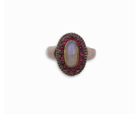 An opal and garnet ring, of cluster design, set with an oval cabochon opal within a border of cabochon garnets, size N1/2  PL
