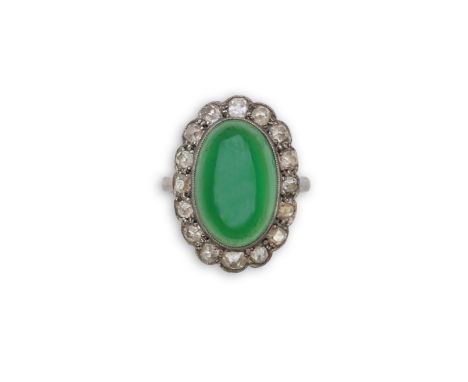 A green chalcedony and diamond ring, early 20th century, of cluster design, set with an oval green chalcedony cabochon within