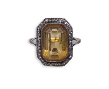 A citrine and diamond ring, early 20th century, set with a step-cut citrine within a border of rose-cut diamonds, to foliate 