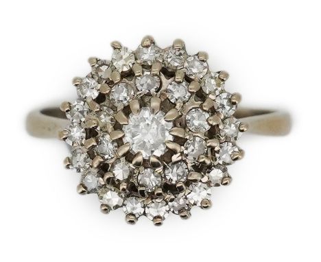 A diamond ring, of cluster design, set with a brilliant-cut diamond within two concentric bands of single-cut diamonds, size 