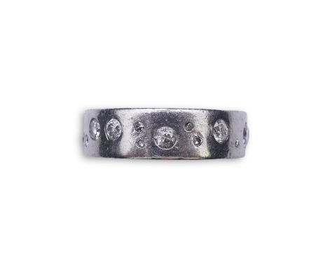 A platinum and diamond eternity ring, set with a continuous band of scattered brilliant-cut diamonds totalling approximately 