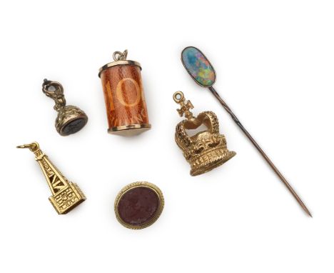 Five charms and an opal stick pin, comprising: a 9ct gold charm enclosing a 10 shilling note, British hallmarks, length 2.9cm