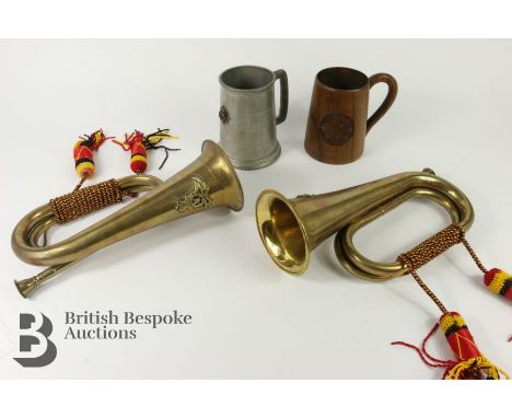 Two military brass bugles, both with Royal Artillery insignia, a Royal Service Corp treen tankard, a pewter regimental tankar