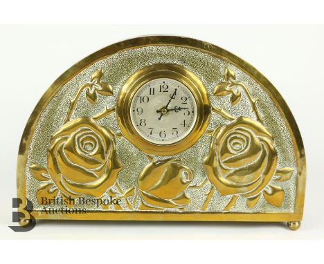20th century brass cased mantel clock, embossed with roses. The clock havig a brushed steel face with black Arabic letters, a