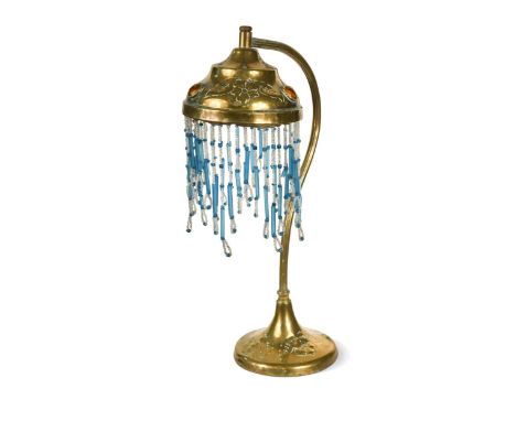 An Art Nouveau brass desk lamp,  the base and shade similarly decorated with an intaglio design of flowers and leaves, the sh