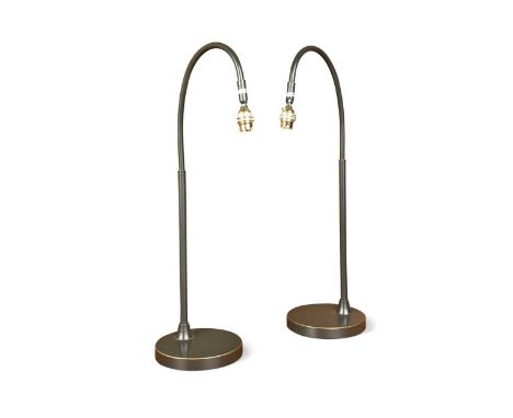 A pair of contemporary bronzed metal reading or bedside lamps, each with circular weighted base, curved stem and adjustable b
