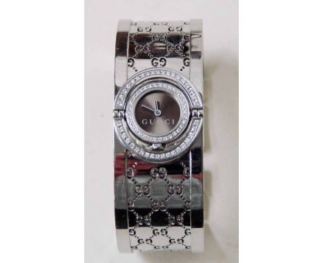 A modern ladies Gucci wrist watch, series 112 Twirl Bangle style, set with diamond to bezel and frame, open work bangle strap